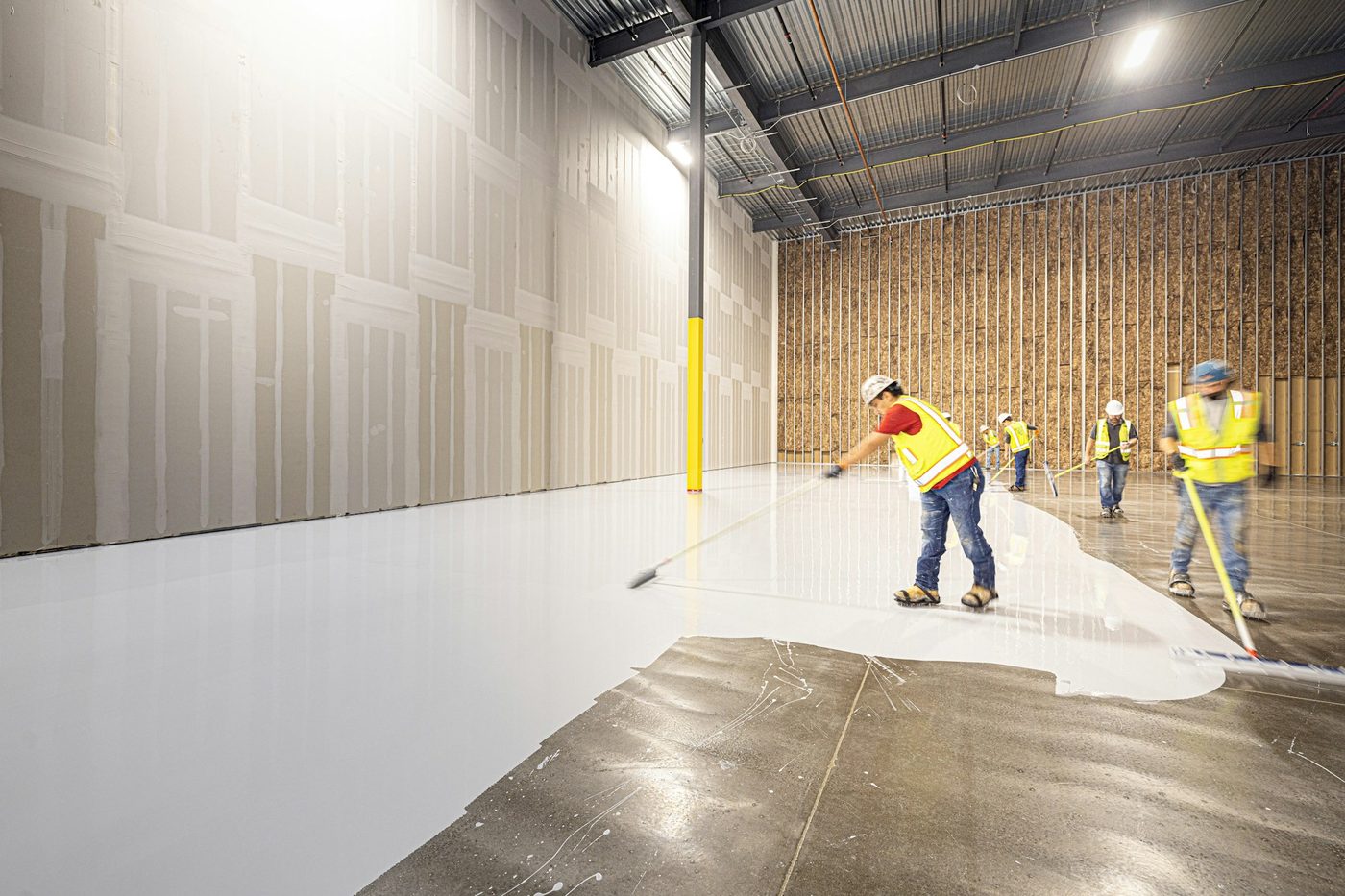 A Westcan painter cutting in a wall on a large commercial interior