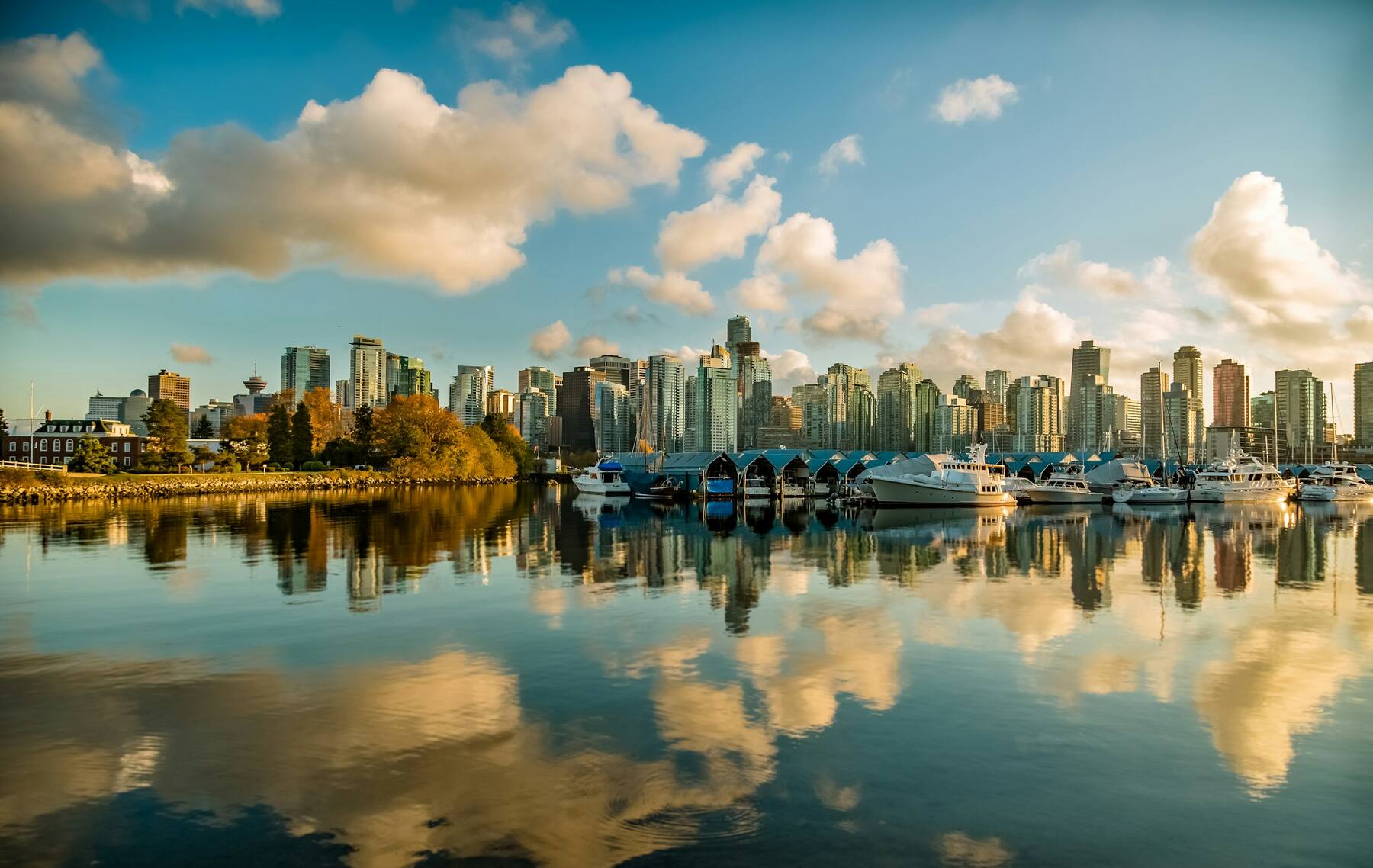 Vancouver downtown skyline at golden hour, viewed across Coal Harbour with the marina in foreground