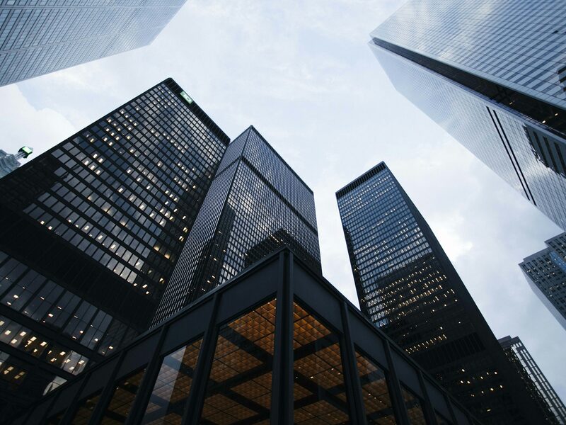 A cluster of modern downtown office towers seen from street level looking up